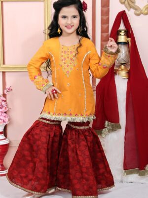 Nikhaar Creations Kids Yellow Cotton Silk Top with Machine Embroidery on front yoke, hemline and sleeves. Worn with Maroon Jacquard Sharara and Maroon Georgette Dupatta with tassles.